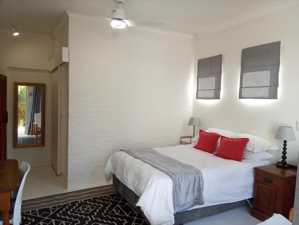a bedroom with a large white bed with red pillows at 273 Rhino retreat-solar backup in Centurion