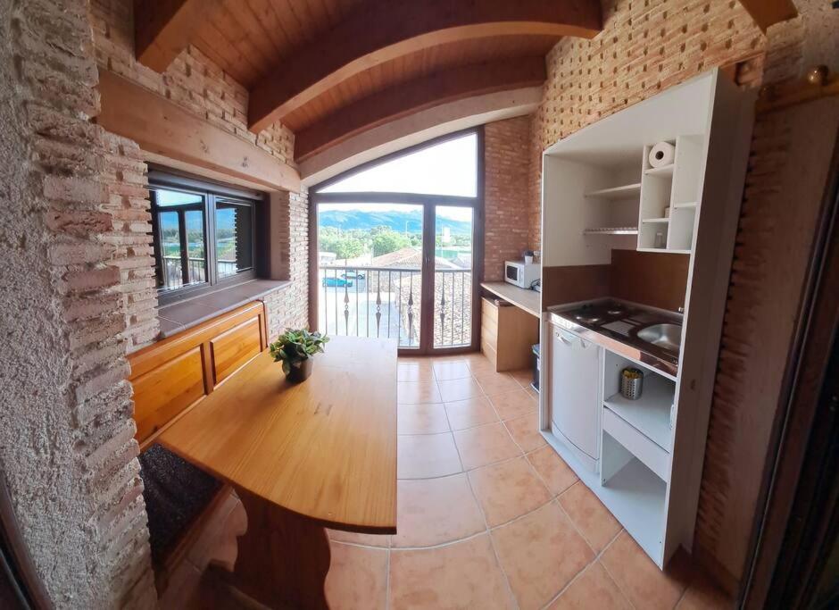 a kitchen with a wooden table in a room at El Mondalindo, Acogedor apartamento mirador in Lozoyuela