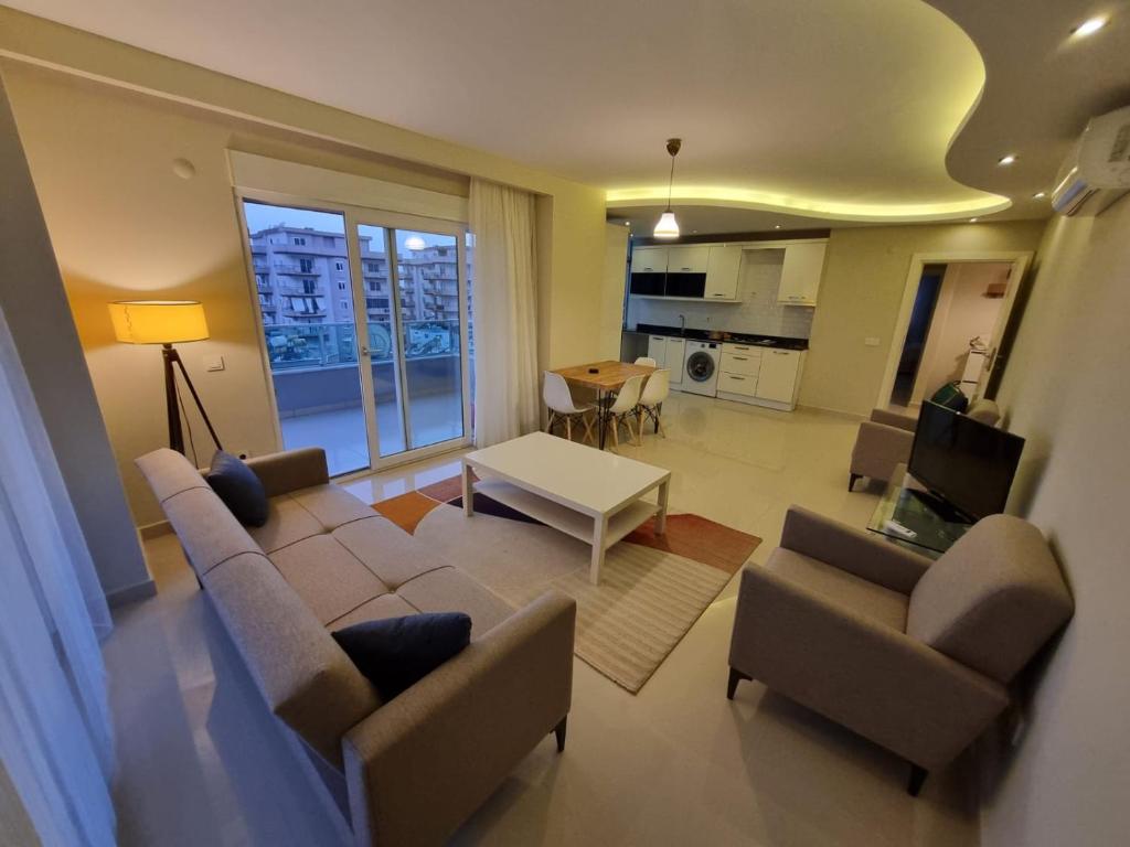 a living room with a couch and chairs and a table at Kleopatra Carina Apart in Alanya