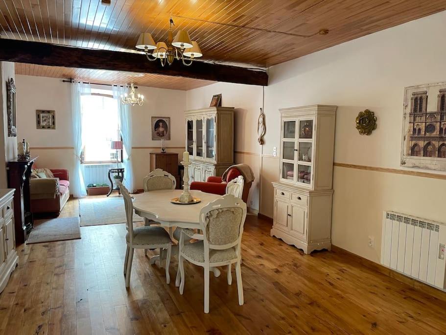 een woonkamer met een tafel en stoelen bij Maison de village en pierre in Saint-Cyprien