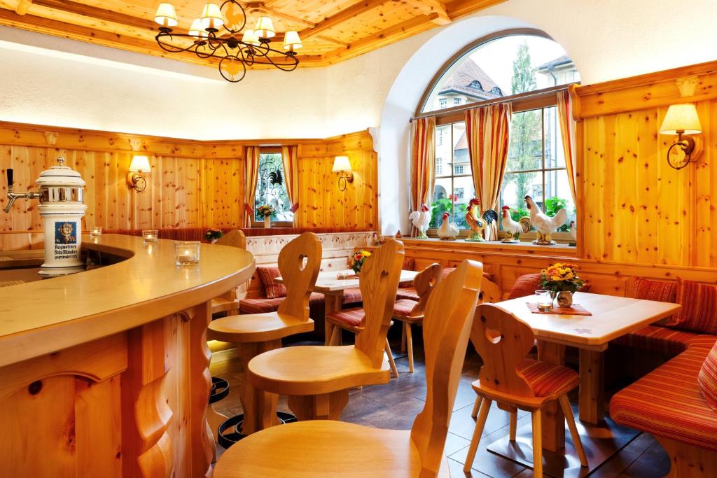 un ristorante con pareti in legno e tavoli e sedie in legno di Hotel Hahn a Monaco