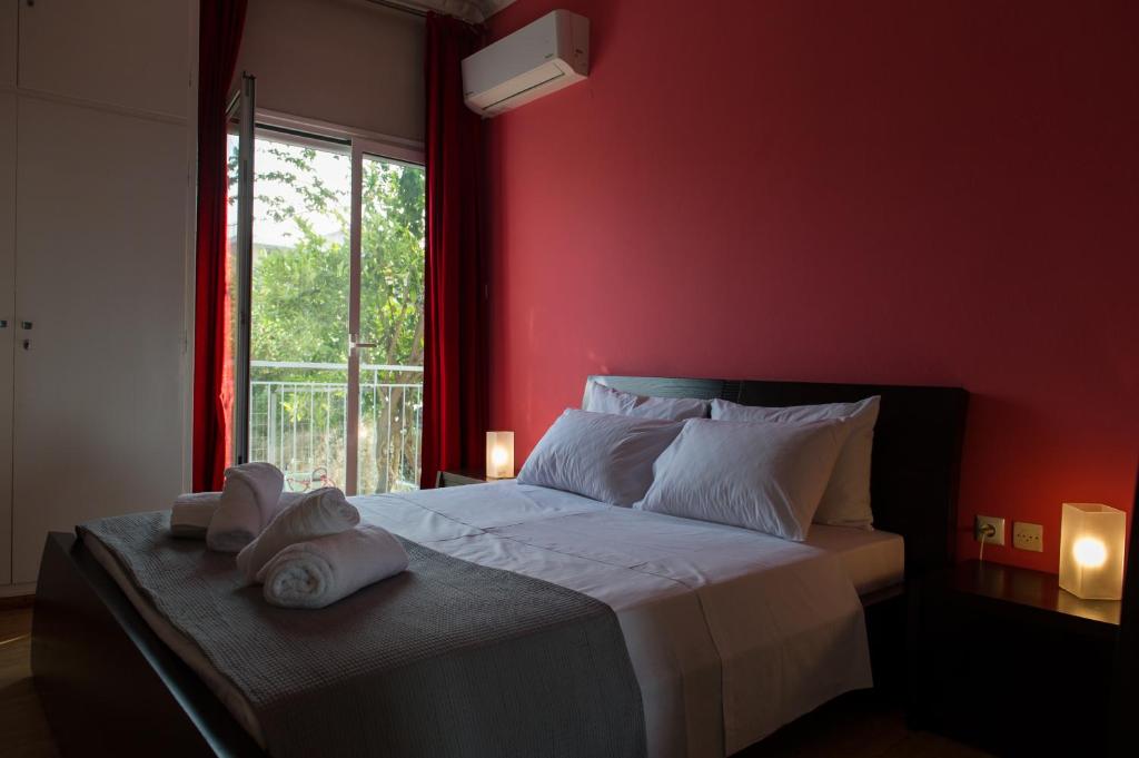 a red bedroom with a bed with towels on it at ΠΙΘΟΣ ΕΝΟΙΚΙΑΖΟΜΕΝΗ ΚΑΤΟΙΚΙΑ in Kalamata