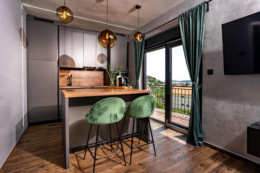 a kitchen with a counter and two green stools at Modern studio with a beautiful view in Rab