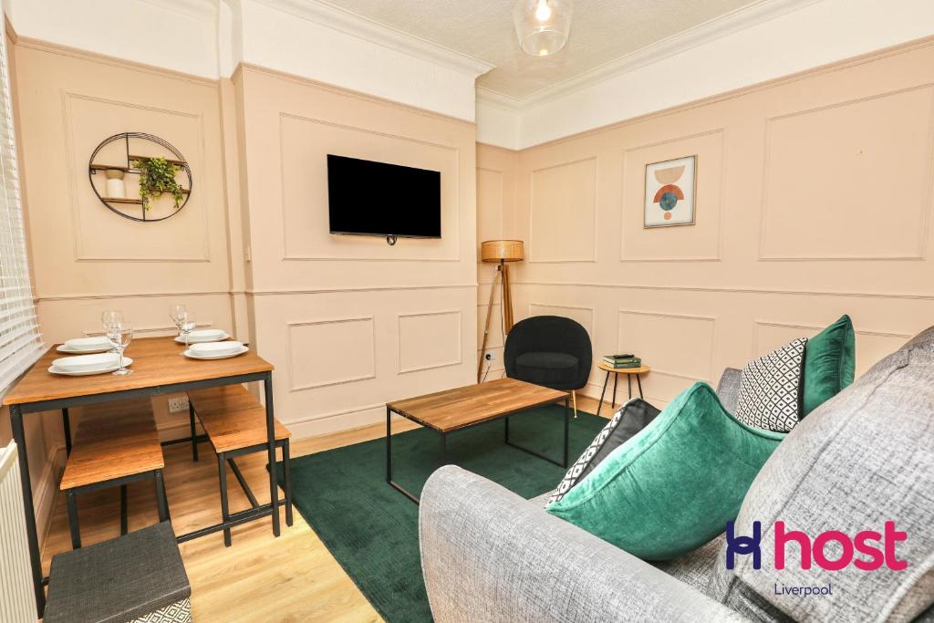 a living room with a table and a tv at Host Liverpool - Chic family spot, near Anfield & centre in Liverpool