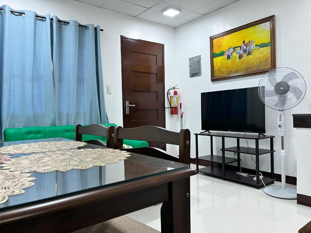 a living room with a table and a tv at HRS APARTELLE in Talisay