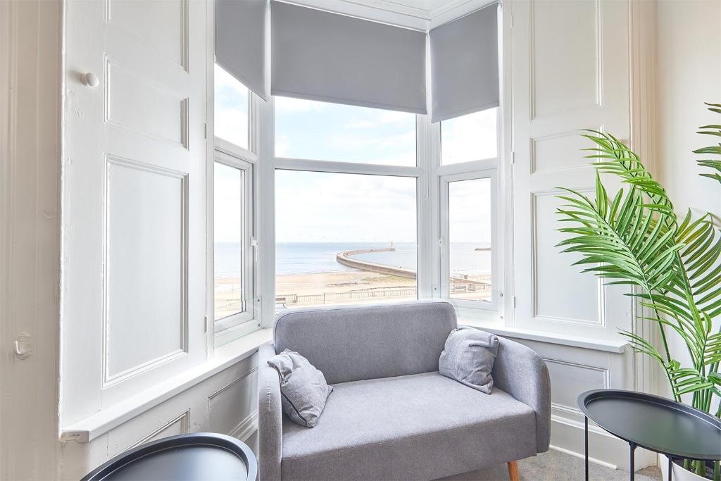 een kamer met een raam met uitzicht op het strand bij 5 Roker Terrace - Seaview apartments in Sunderland