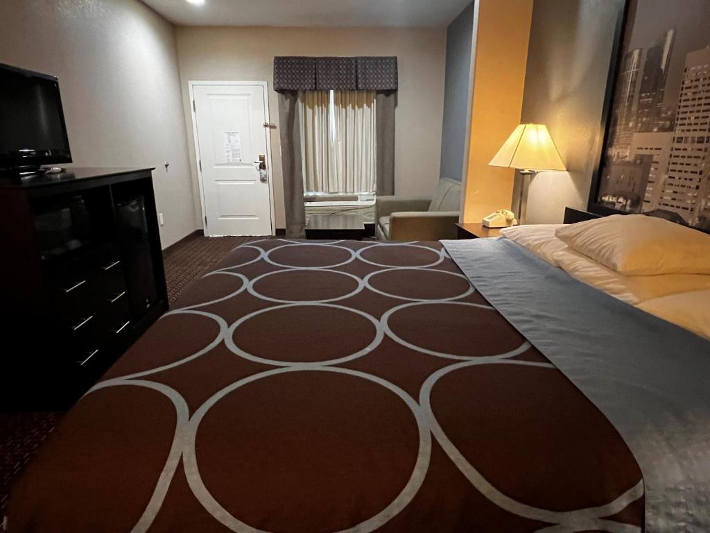 ein Hotelzimmer mit einem großen Bett und einem TV in der Unterkunft Super 8 by Wyndham Center in Center