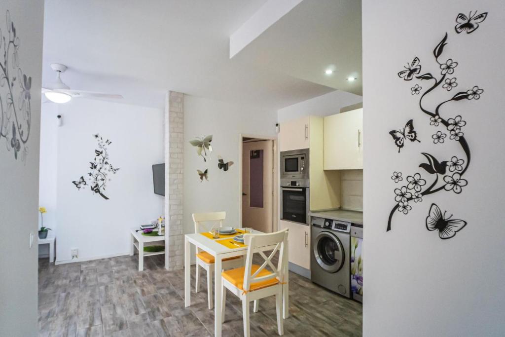 コスタ・デル・シレンチオにあるMARIPOSA en Frontera/Primaveraのテーブル付きの部屋、蝶が壁に浮かぶキッチンが備わる客室です。