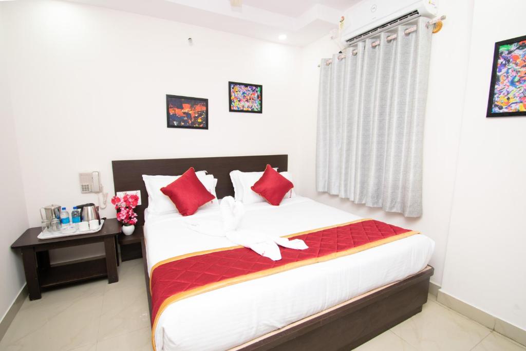 1 dormitorio con 1 cama grande con almohadas rojas en Octave Hotel JM Residency, en Bangalore