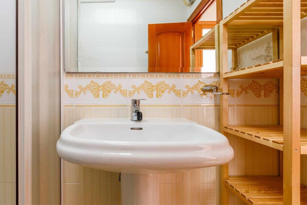 łazienka z białą umywalką i lustrem w obiekcie A&N Casa del Sol w mieście Torre del Mar