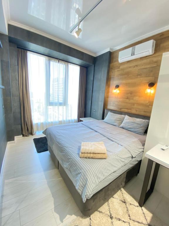 - une chambre avec un grand lit et une fenêtre dans l'établissement Ultracentral Lux Apartment, à Chişinău