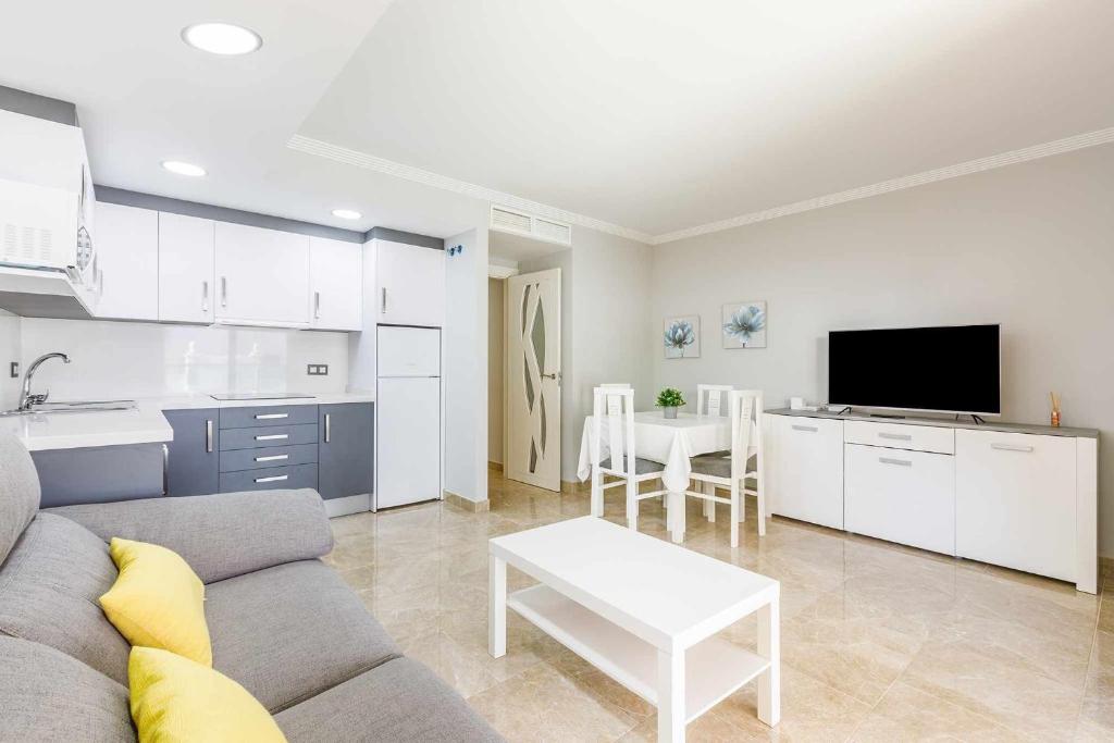 a kitchen and a living room with a couch and a table at A&N La Cueva 2 in Torre del Mar