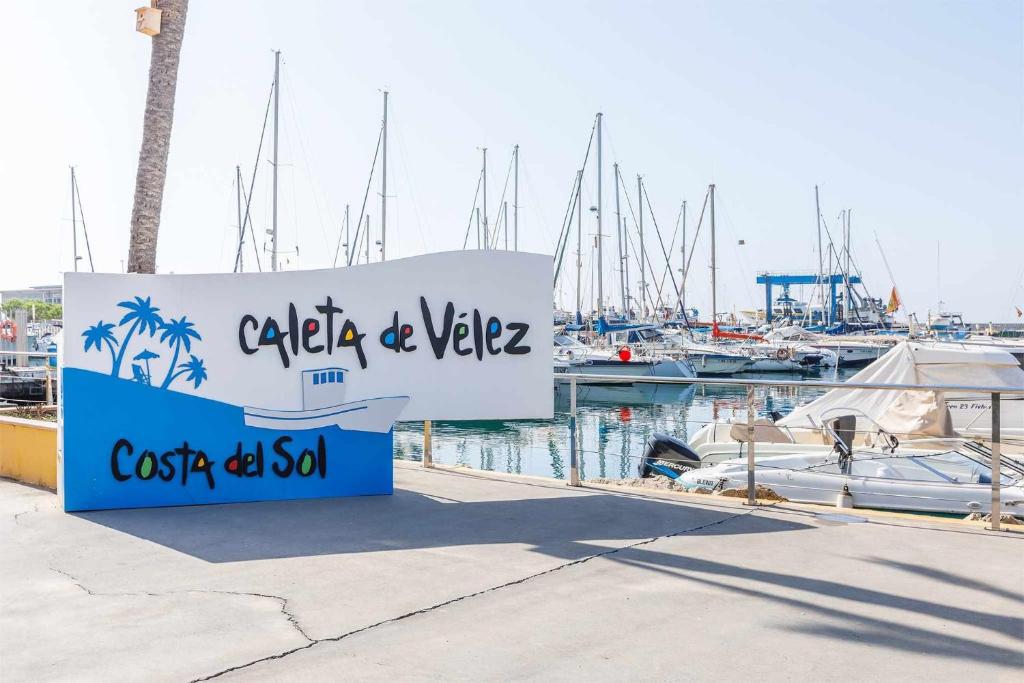 un cartello per un porto turistico con barche in acqua di A&N Seaport 1B a Caleta de Velez