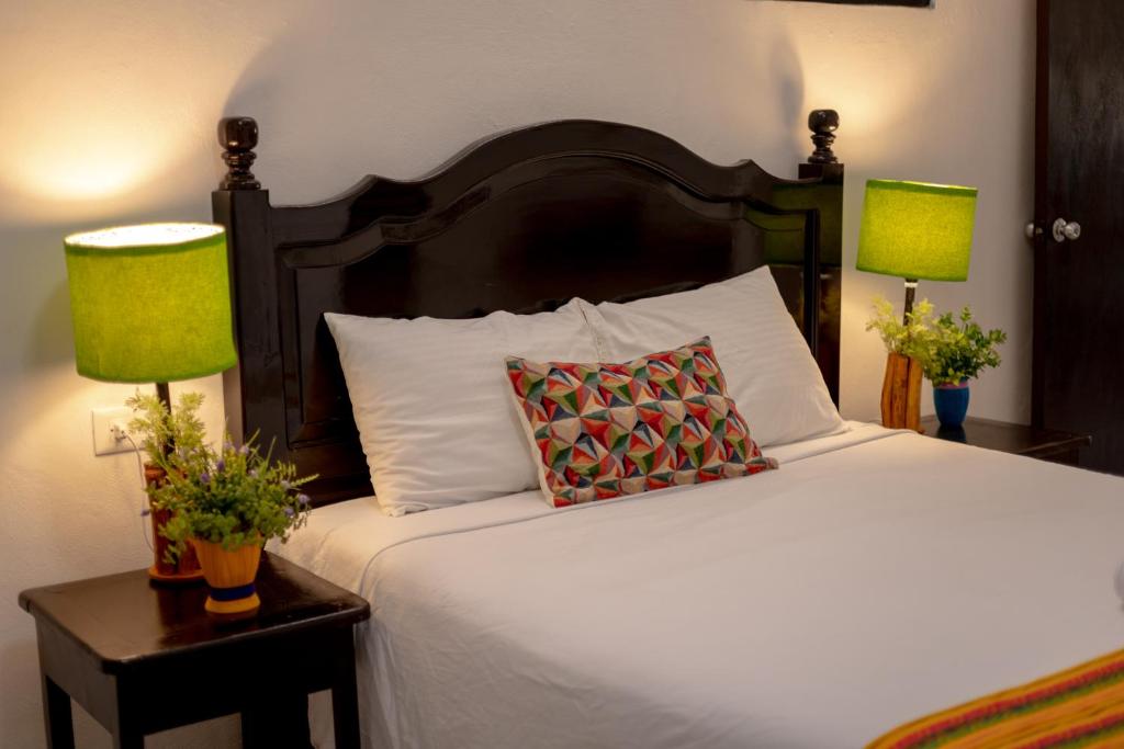 1 dormitorio con 1 cama grande y 2 lámparas en Casa Makech, en Valladolid