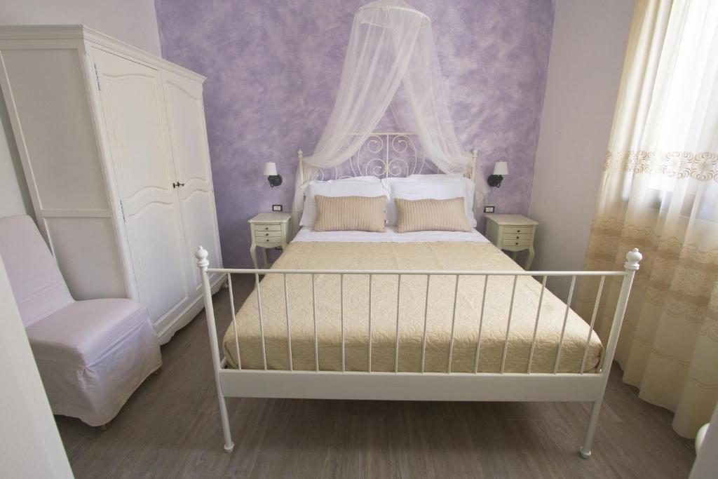 a bedroom with a white bed with a canopy at Venustas in Lampedusa