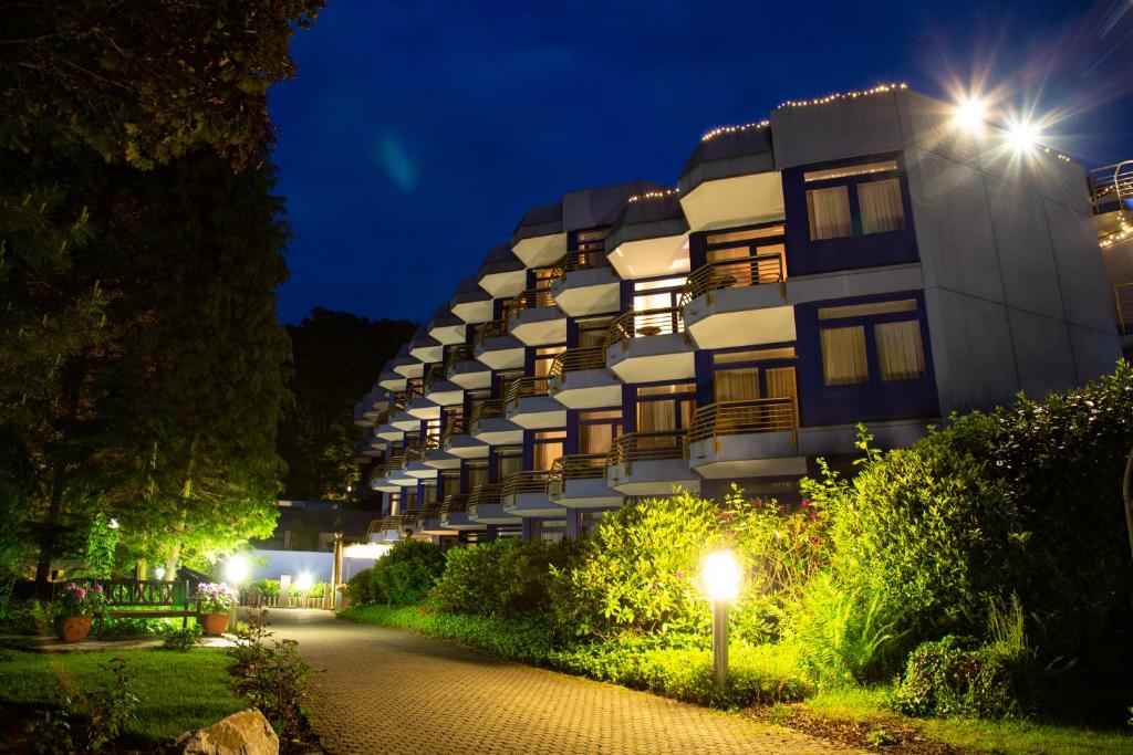 a building with lights on the side of it at night at Fini-Resort Badenweiler in Badenweiler