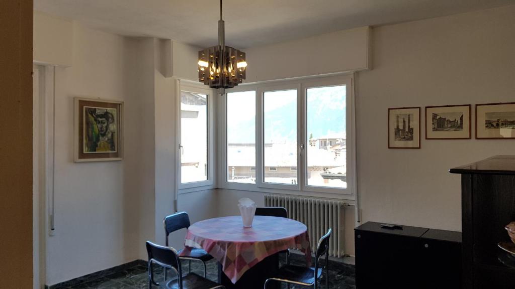 ein Esszimmer mit einem Tisch, Stühlen und einem Fenster in der Unterkunft Casa Liver Pieve in Tremosine sul Garda