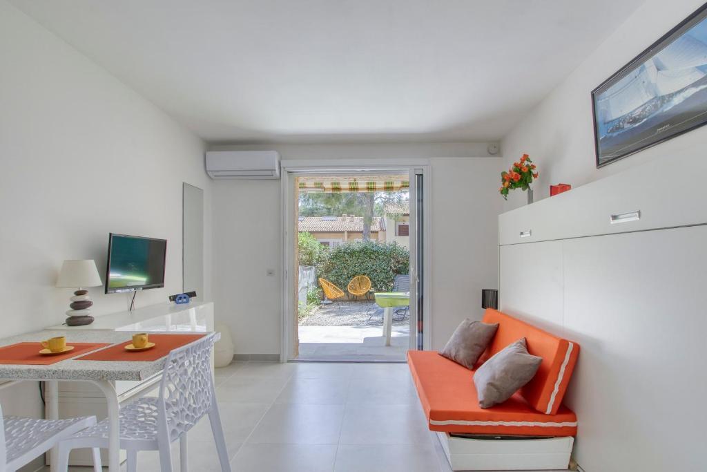 un salon avec un canapé orange et une table dans l'établissement Isulita - Studio climatisé à 400m de la mer, à Bandol
