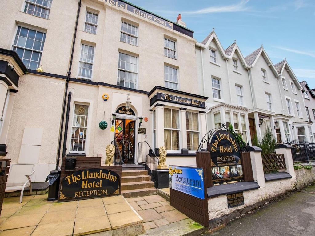 a large white building with a sign in front of it at The Llandudno Hotel in Llandudno