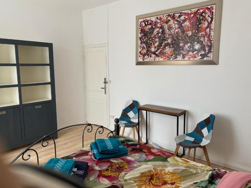 een woonkamer met 2 stoelen en een schilderij aan de muur bij BnB Maison d'Art Breakfast in the Art Gallery in Ploubazlanec