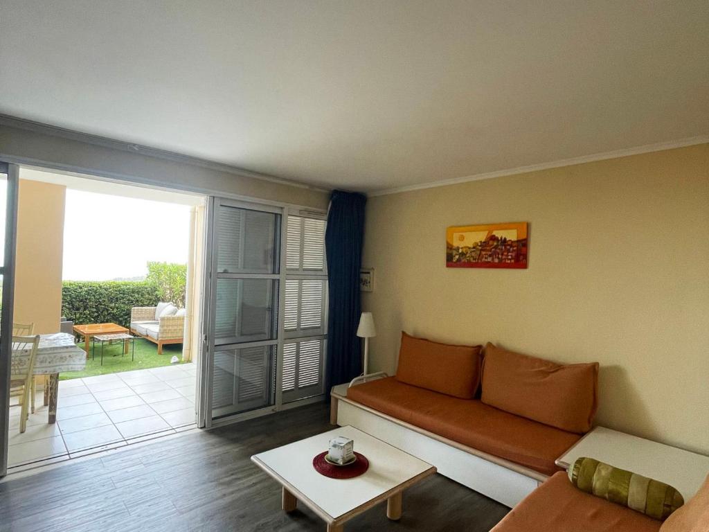 un salon avec un canapé et une table dans l'établissement 2 pièces en rez-de-jardin avec vue mer, piscine et parking à Saint-Raphaël - FR-1-504-567, à Saint-Raphaël