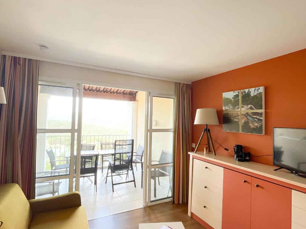 een woonkamer met een televisie en een balkon bij Appartement Saint-Raphaël, 3 pièces, 6 personnes - FR-1-504-418 in Saint-Raphaël