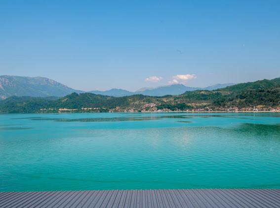 uma grande massa de água com montanhas ao fundo em Apartmani Jezero em Konjic