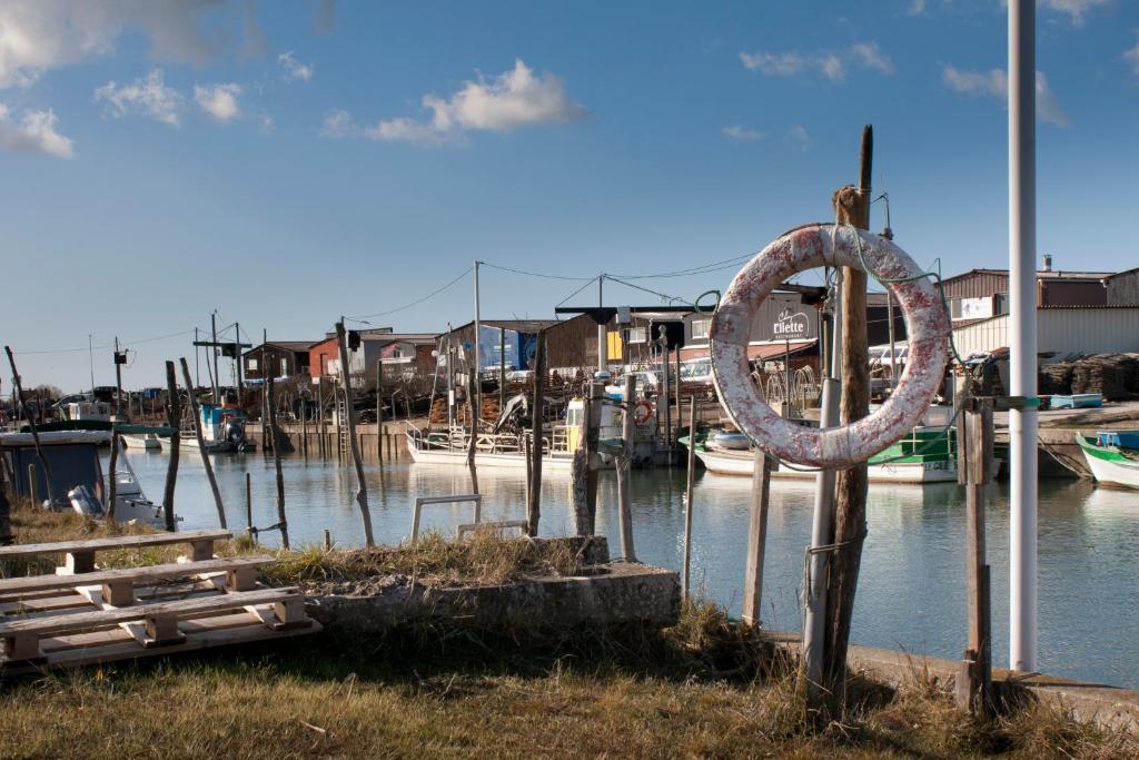 a marina with boats in the water and a metal sculpture at Andernos-Maison de centre-ville avec jardin in Andernos-les-Bains