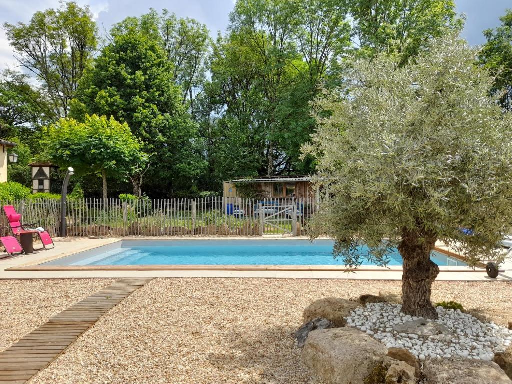 a tree in front of a swimming pool at LeS GITES CAMBOIS in Cambes