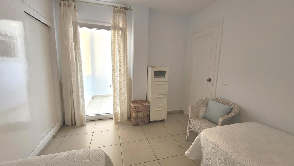 sypialnia z łóżkiem, krzesłem i oknem w obiekcie A&N Ipanema 3 w mieście Torre del Mar