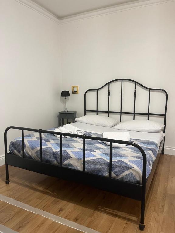 a bed in a white room with a black frame at Anema e Core in Naples