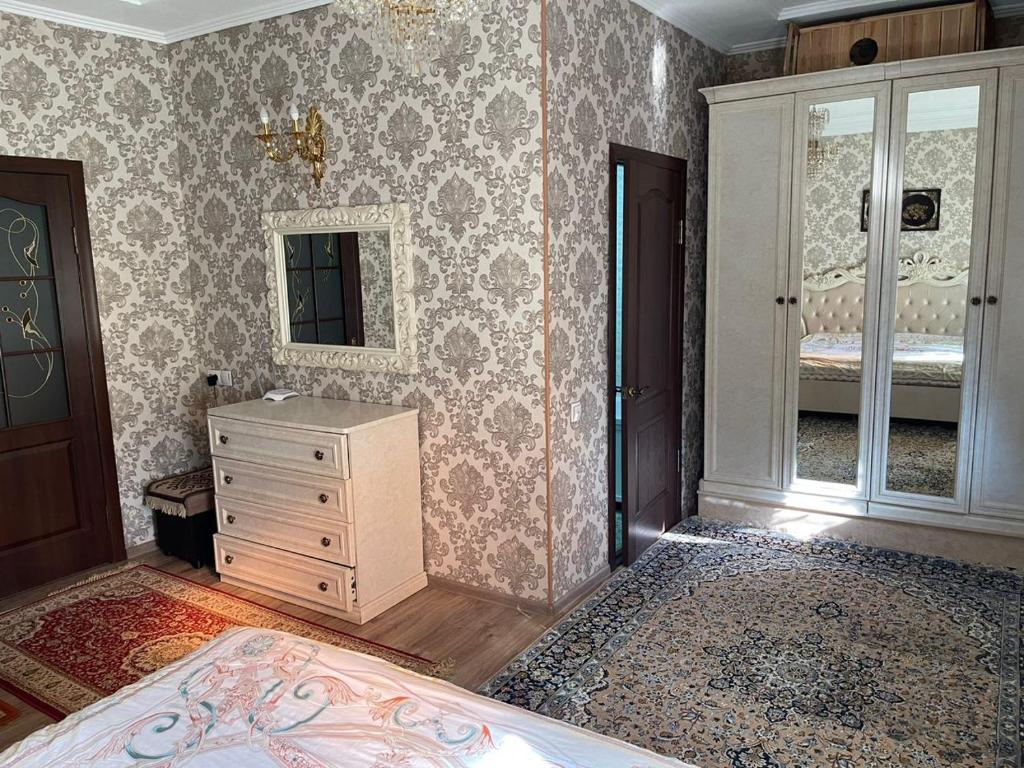 a bedroom with a bed and a dresser and a mirror at Тумар in Osh