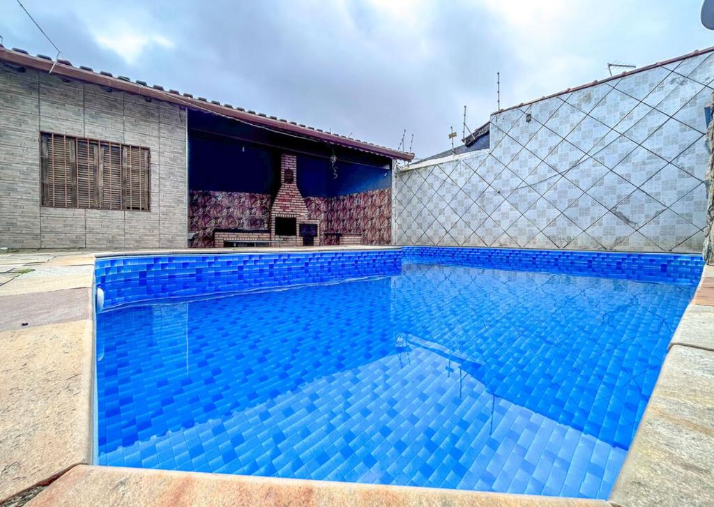 duży niebieski basen obok budynku w obiekcie Casa c piscina a 260m da Praia Itaoca Mongagua SP w mieście Mongaguá