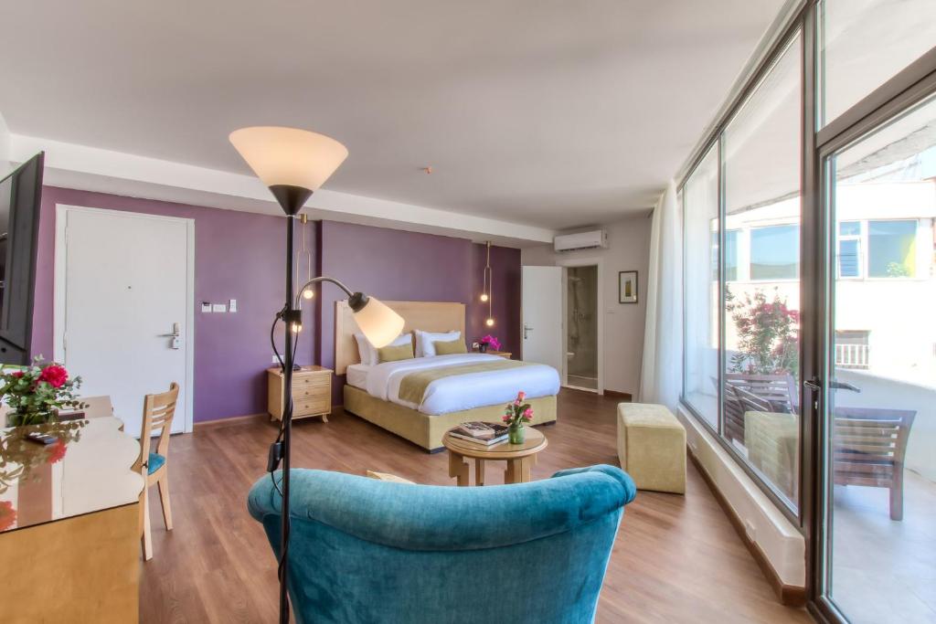 a hotel room with a bed and a blue chair at Liwan Hotel in Amman