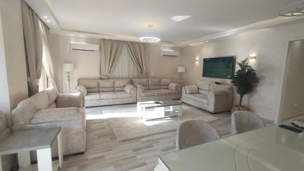 uma grande sala de estar com sofás e uma televisão em التجمع الخامس no Cairo