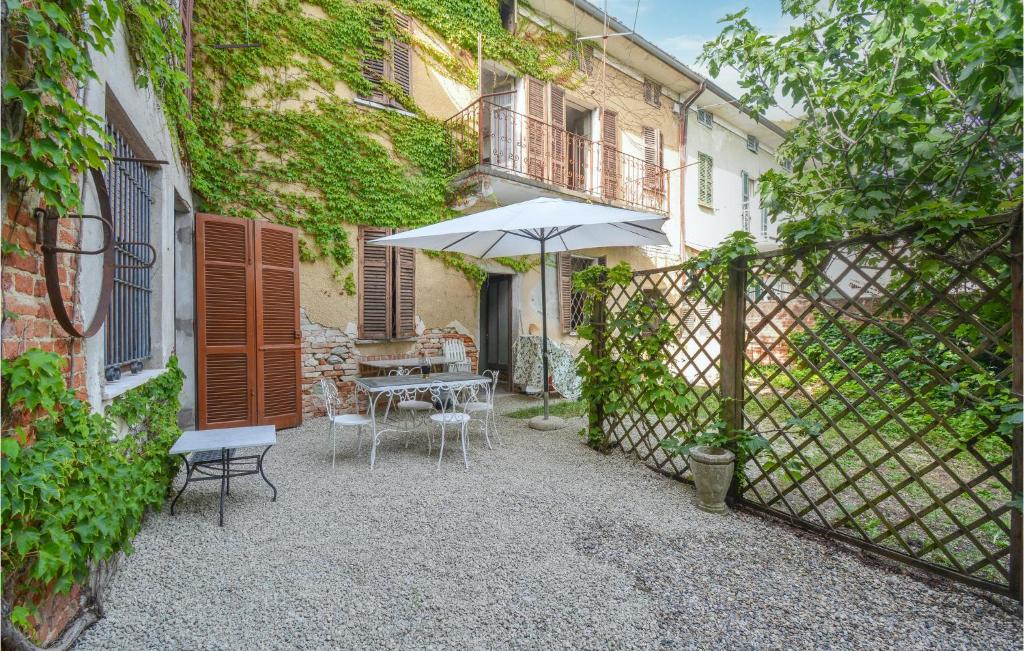 een patio met een parasol en een tafel en stoelen bij Gorgeous Home In Cuccaro Monferrato Al With Kitchen in Cuccaro Monferrato