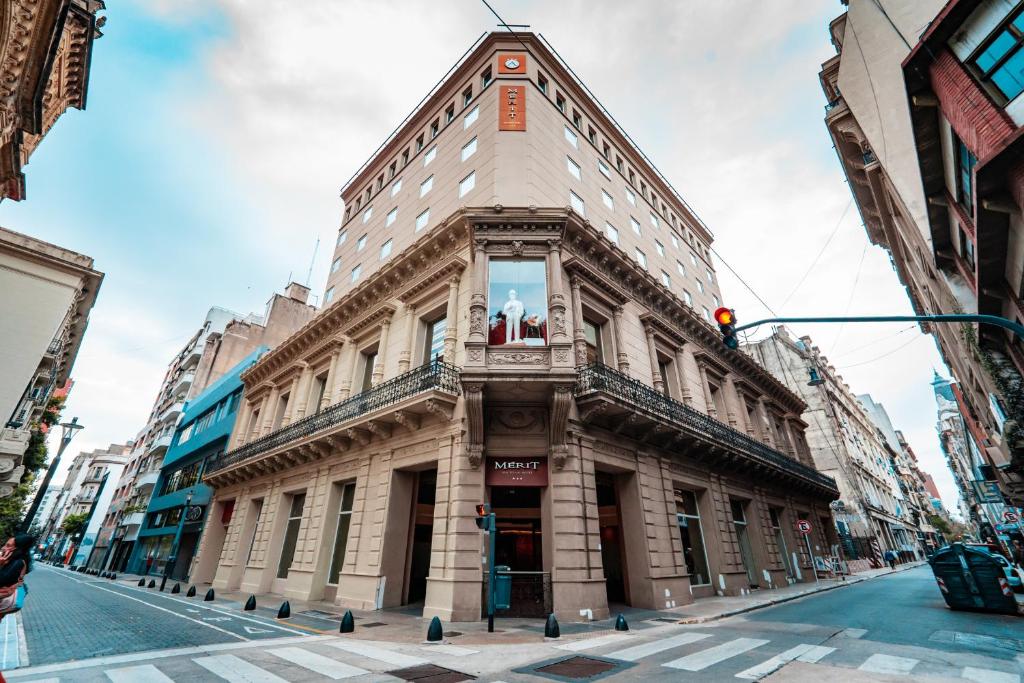 un edificio alto en una calle de la ciudad con un semáforo en Mérit San Telmo en Buenos Aires