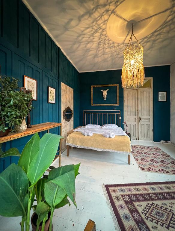 una camera da letto con pareti blu e un letto con un lampadario a braccio di Karma Hostel a Martvili