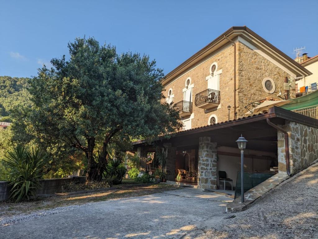 un grande edificio in mattoni con un albero di fronte di La Casa Di Lidia a Cardile