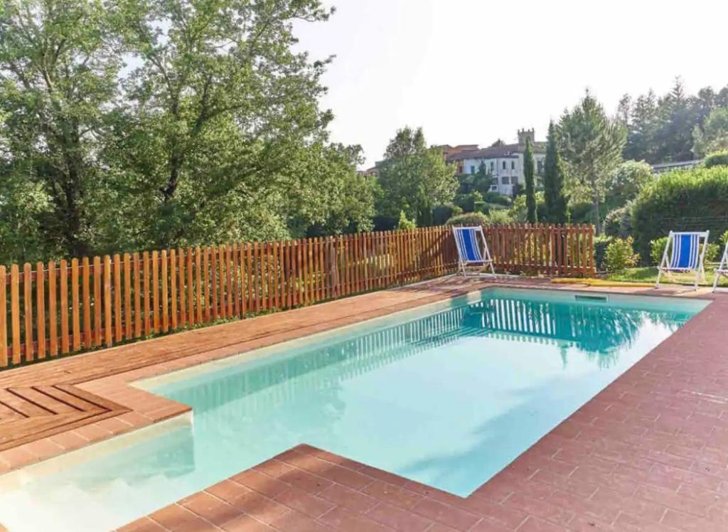 a swimming pool with a wooden fence at Borgo degli Artisti boutique rooms in Serricciolo