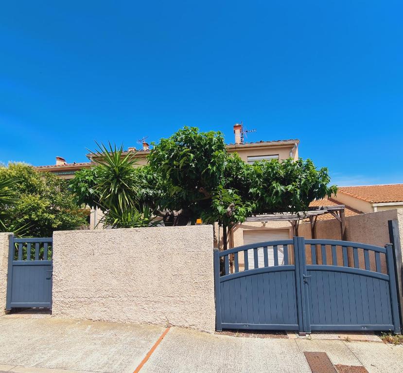 a blue gate in front of a house at Villa standing 10 personnes piscine/ pinède in Canet-en-Roussillon