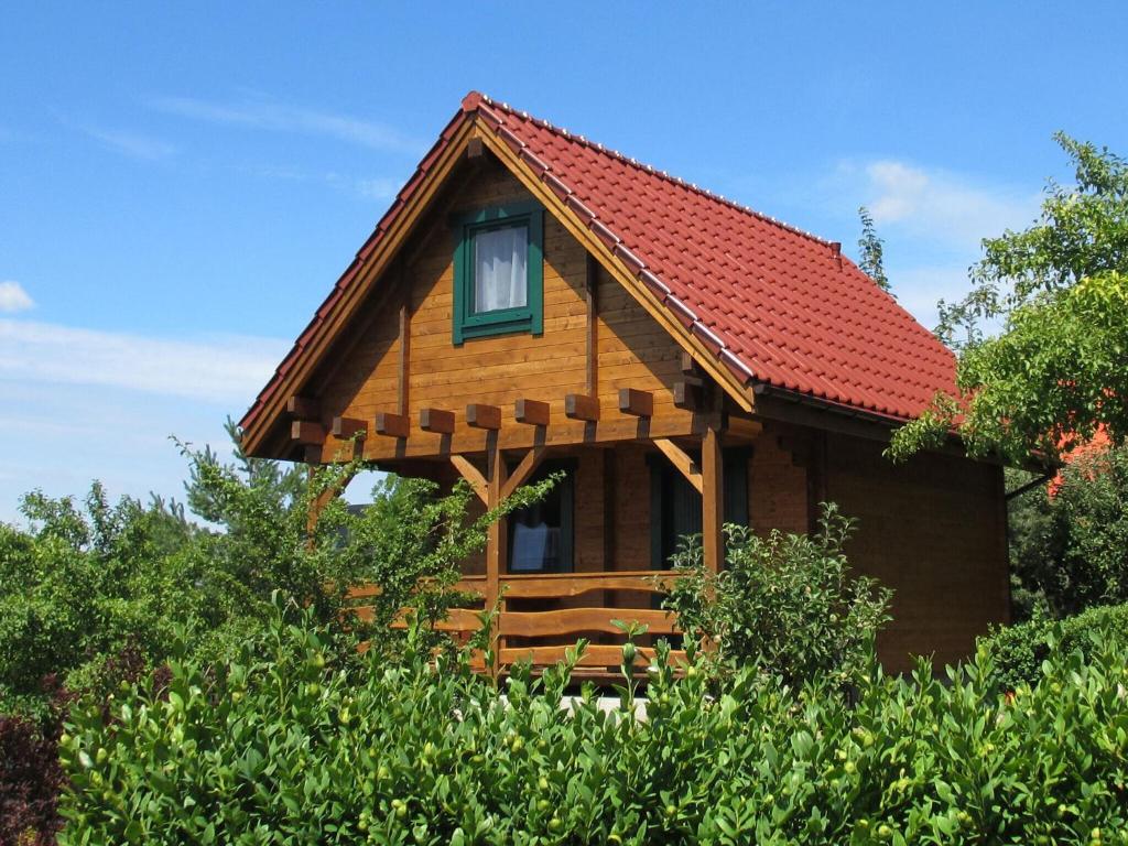 a log cabin with a red roof at Delightful Holiday Home in Lubin with Garden in Międzyzdroje