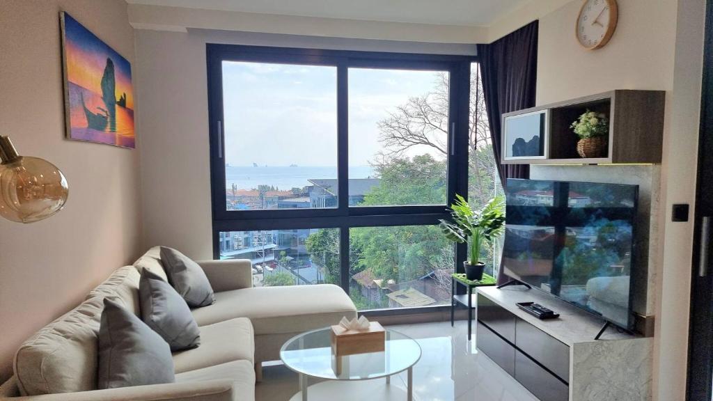 a living room with a couch and a large window at Bo304-Panorama Seaview 1 Bedroom at Ao Nang Beach in Ao Nang Beach