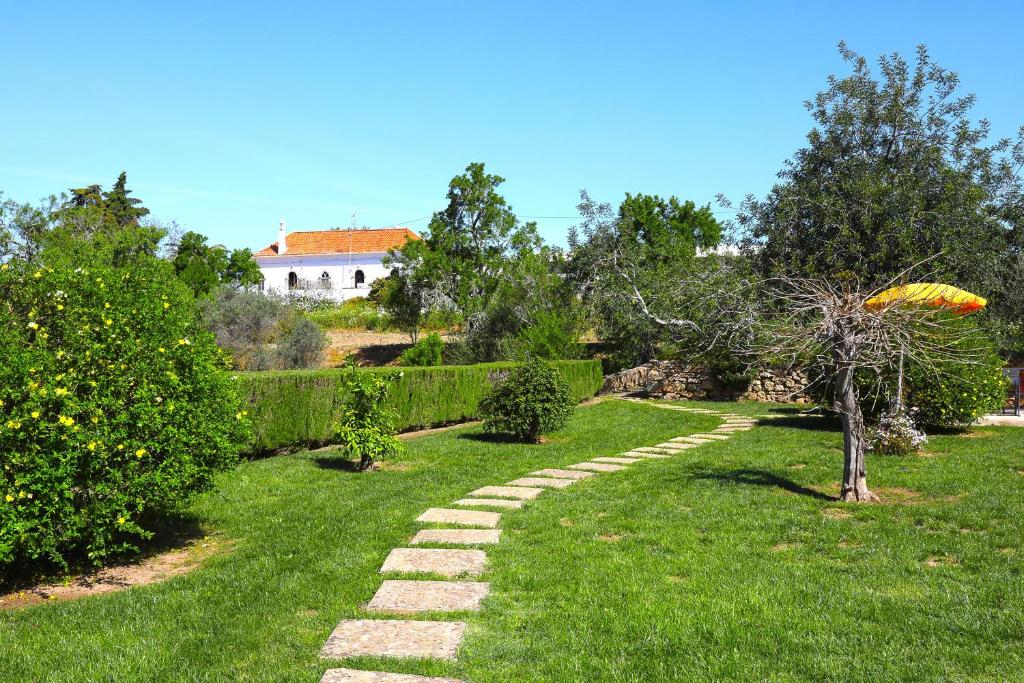 a garden with a stone path in the grass at Vale Formoso-authentic Farmhouse &pool-tavira 3km in Tavira