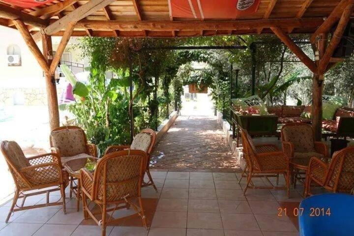 a group of chairs and tables under a pergola at Sonmez Hotel in Oludeniz