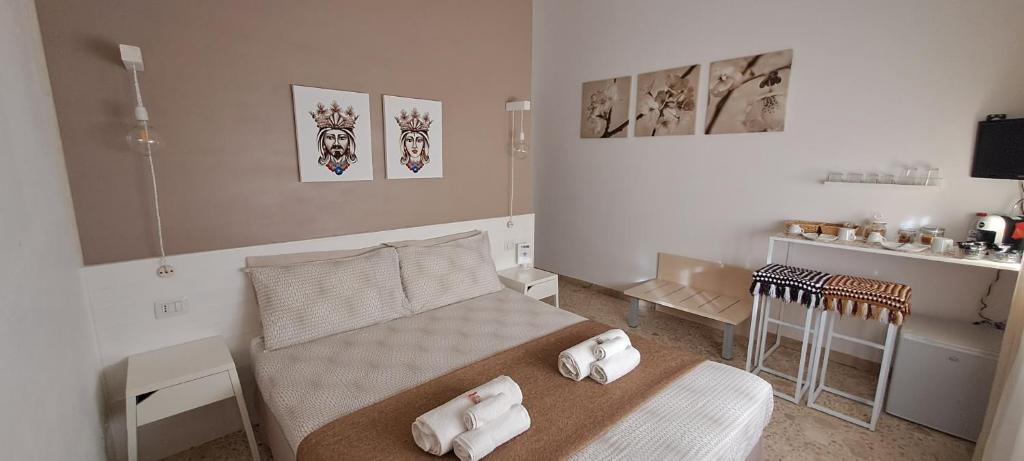 una camera da letto con un letto con due asciugamani bianchi di Il Vaso di Creta a Ragusa
