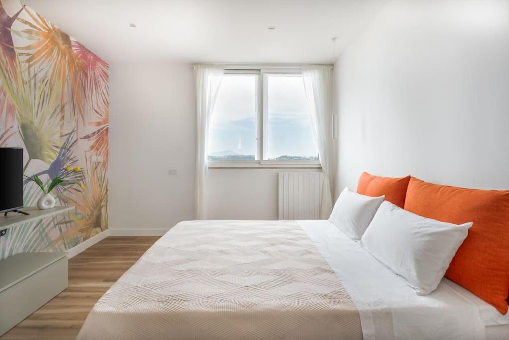 a bedroom with a large bed and a window at Attico 70 - Puteoli Apartament in Pozzuoli