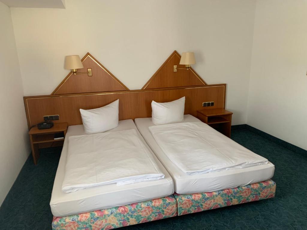 Hotel Garni Eschenbach في هيلدبورغهاوزن: سرير في غرفة بسريرين توأم
