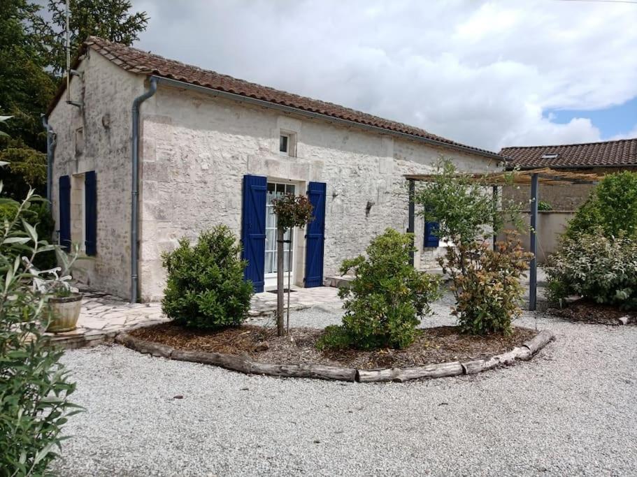 un edificio con una puerta azul y algunos arbustos en Petite maison de charme Les Chats Pîtres, en La Rochette