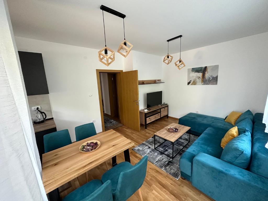 a living room with a blue couch and a table at Apartman Pavlović in Soko Banja